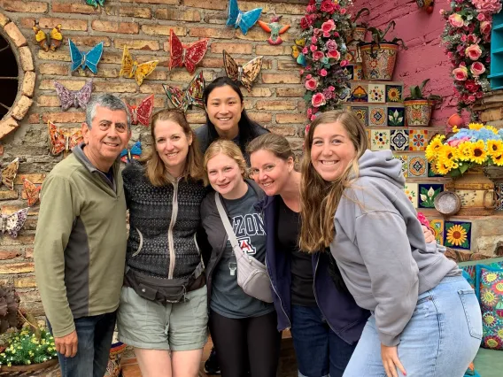 6 adults standing in group smiling at camera