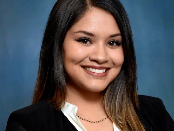 Photo of woman in black blazer smiling at camera