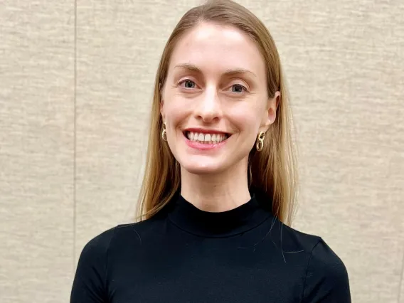 Woman wearing black sweater smiling at camera