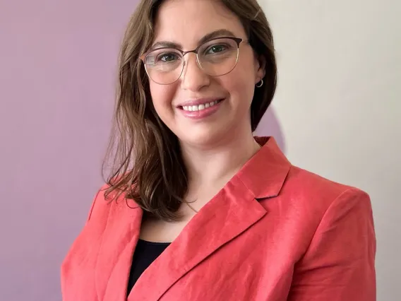 Woman in peach jacket smiling at camera