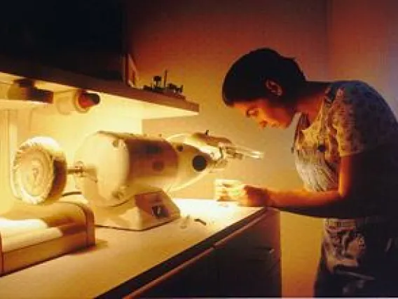 Audiologist refurbishing a hearing aid