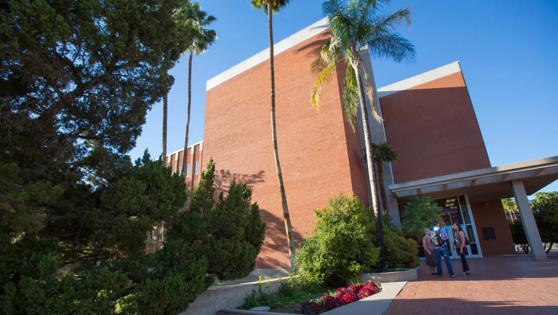 Image of front of SLHS building with people talking