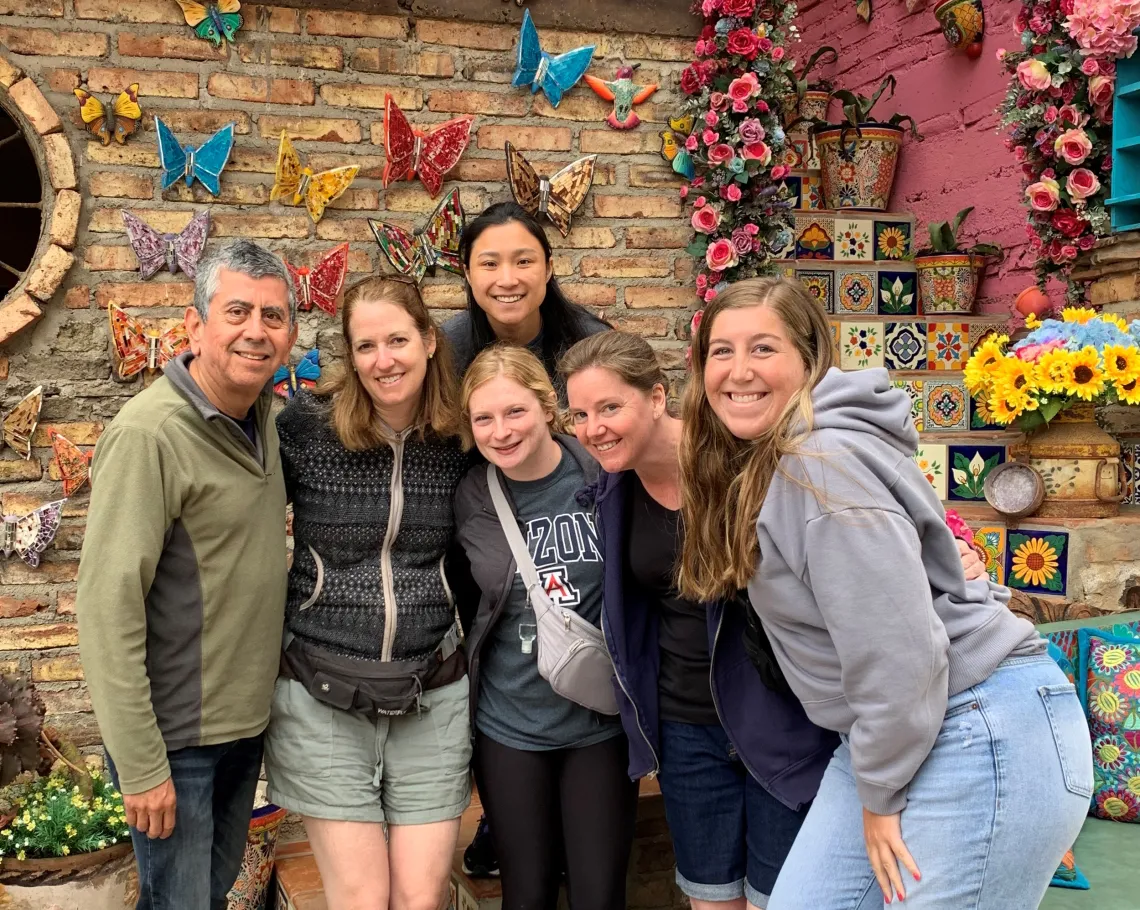 6 adults standing in group smiling at camera