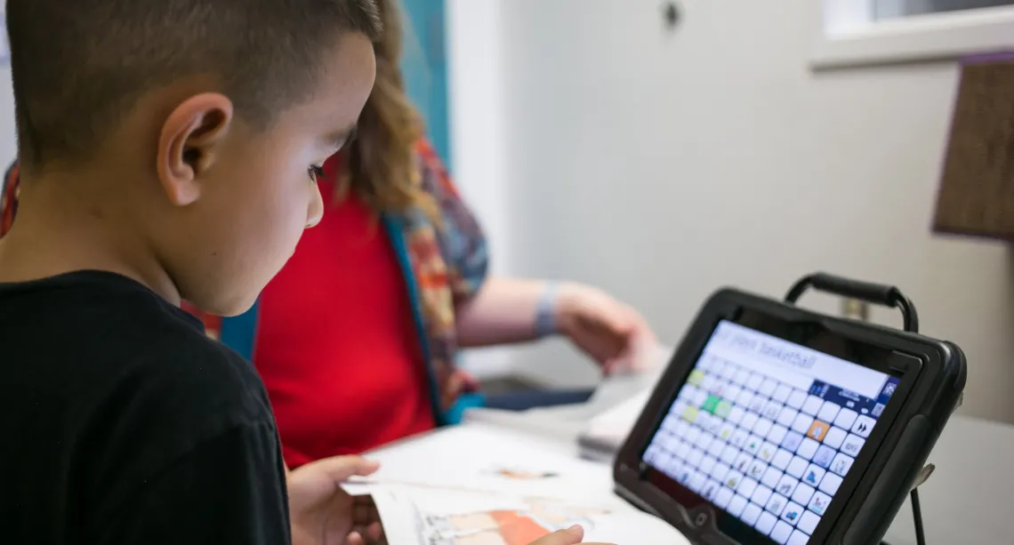 Child looking at speech generating device