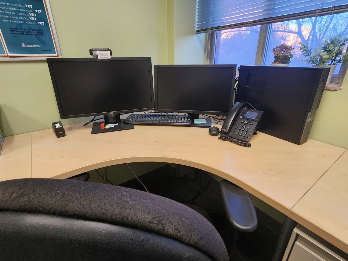 work space in the HUB with two monitors and an office chair facing a window