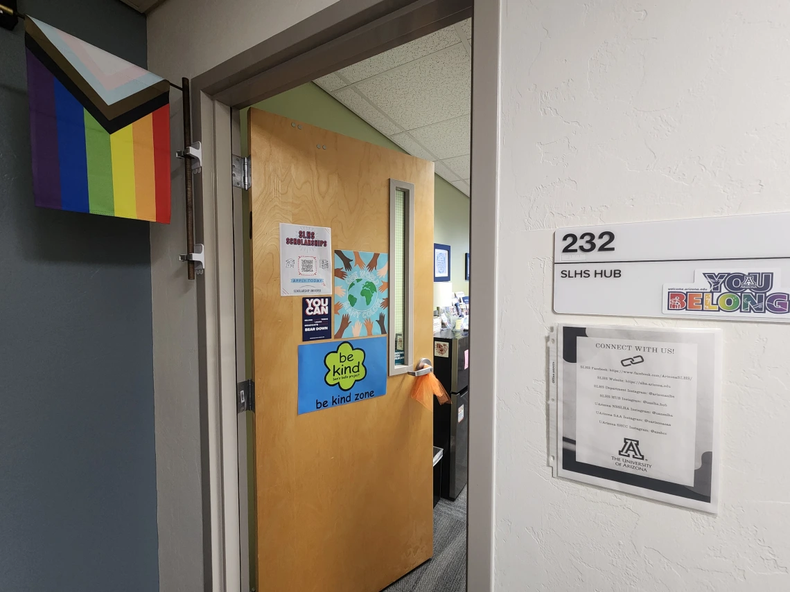 SLHS Room 232 door open showing door sign with progressive pride flag