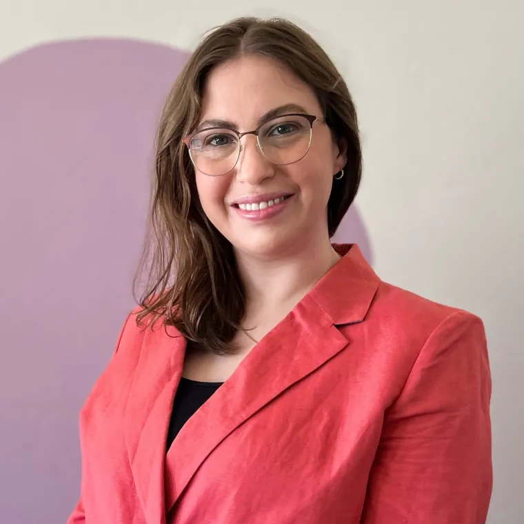 Woman in peach jacket smiling at camera