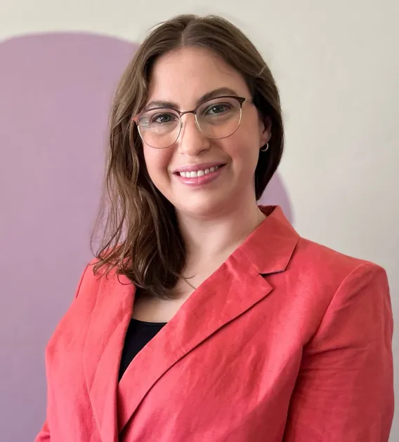 Woman in peach jacket smiling at camera